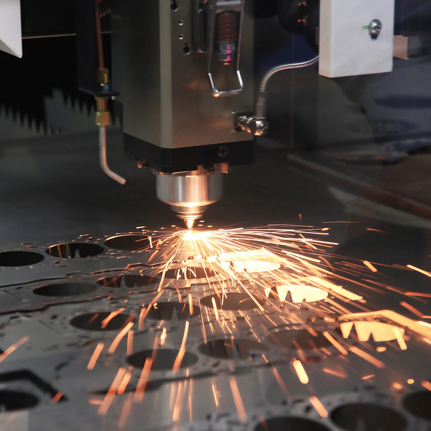 The CNC laser cut machine while cutting the sheet metal with the sparking light