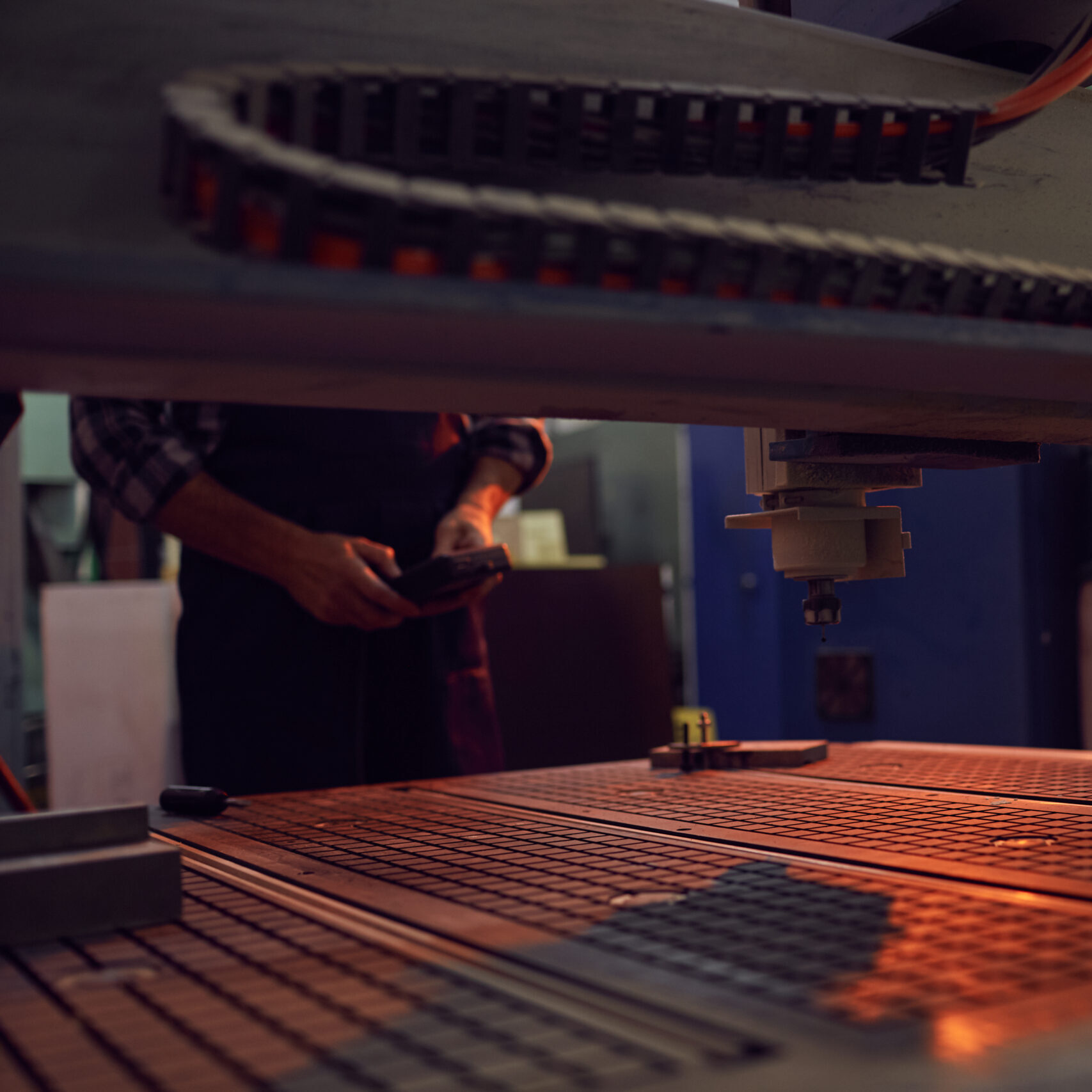 Close-up of work of machine controlled by operator who standing in the background and using remote control